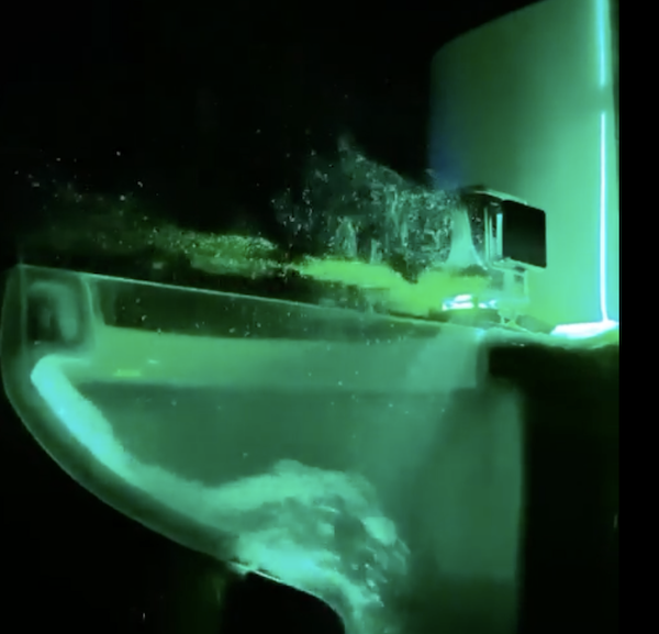 toilet under laser light showing splashing particles